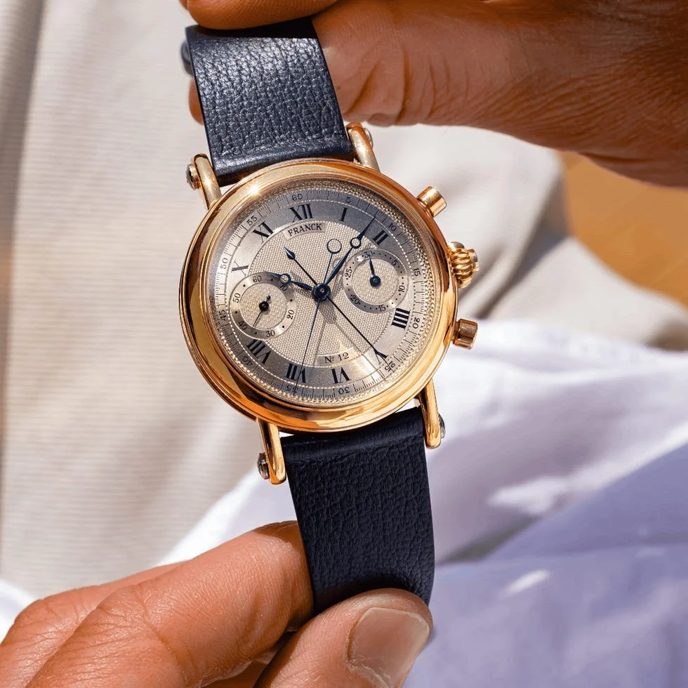 gold chronograph wristwatch with black leather strap. gold chronograph wristwatch with black leather strap.